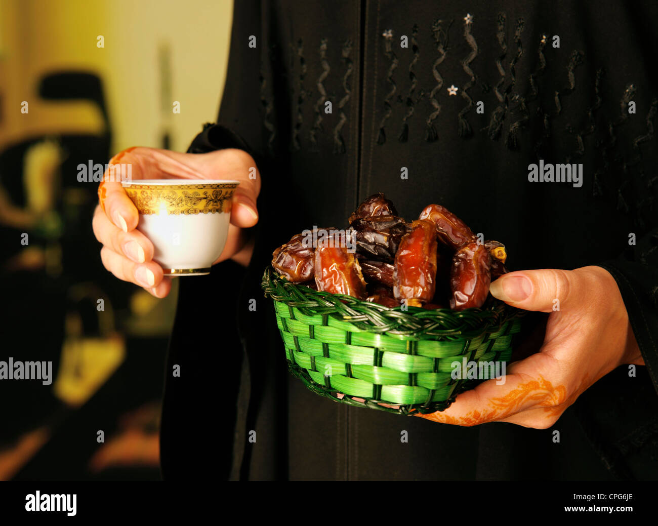 Arab lady with henna on hands holding coffee and dates Stock Photo Alamy