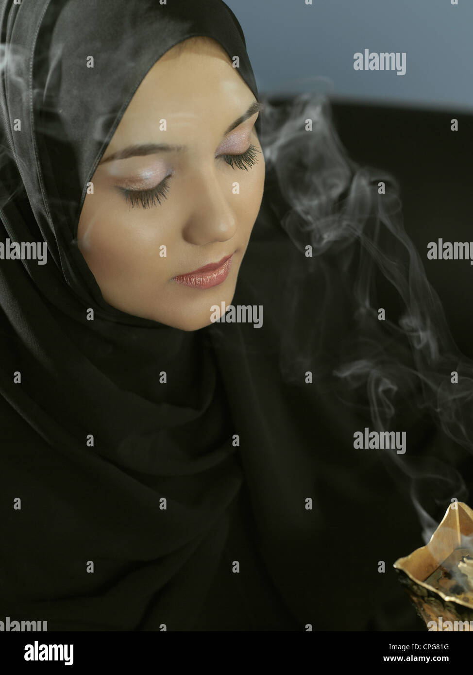 An Arab lady smells the aroma of incense Stock Photo Alamy