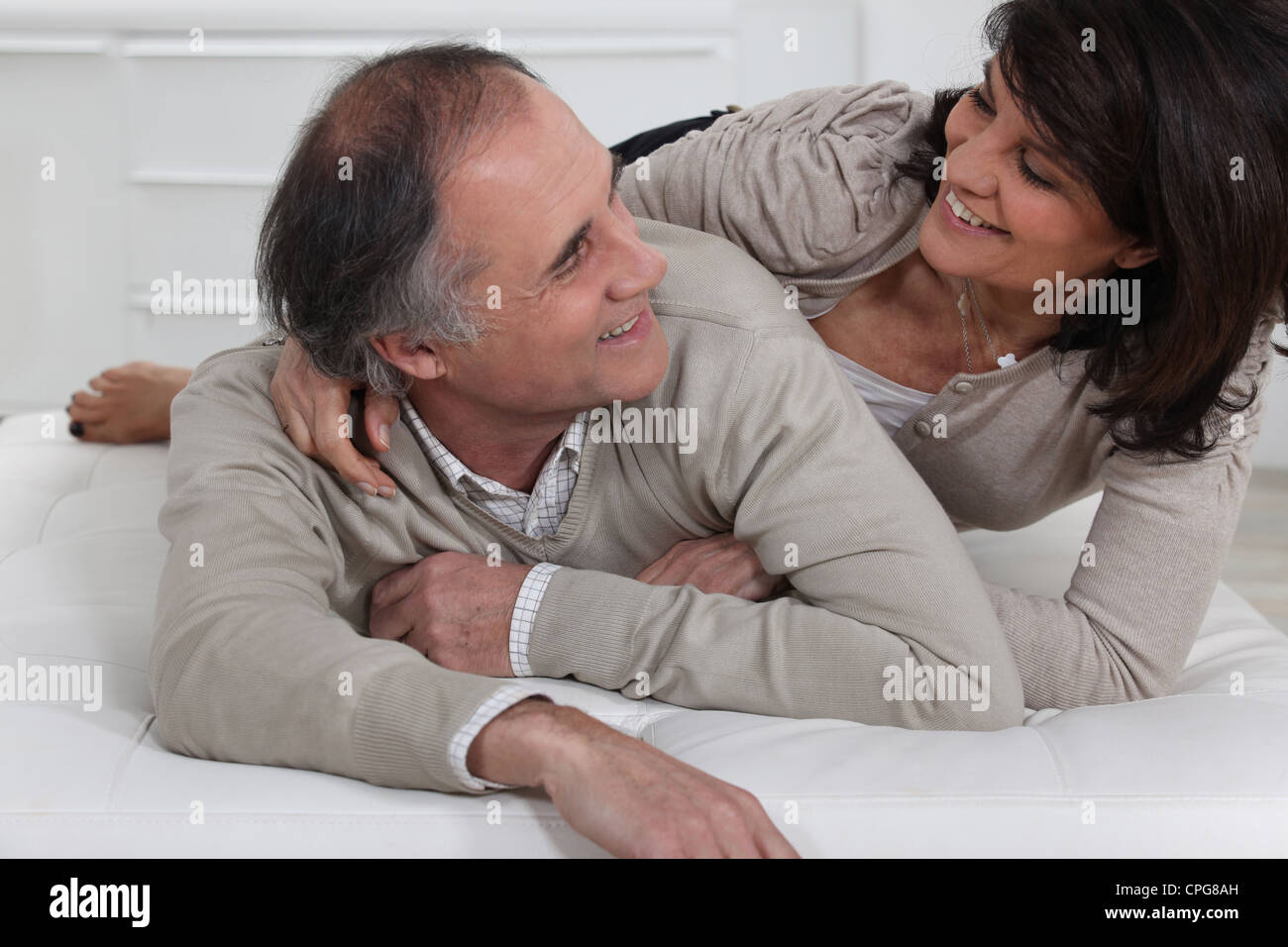 Mature couple lying on a bed Stock Photo - Alamy