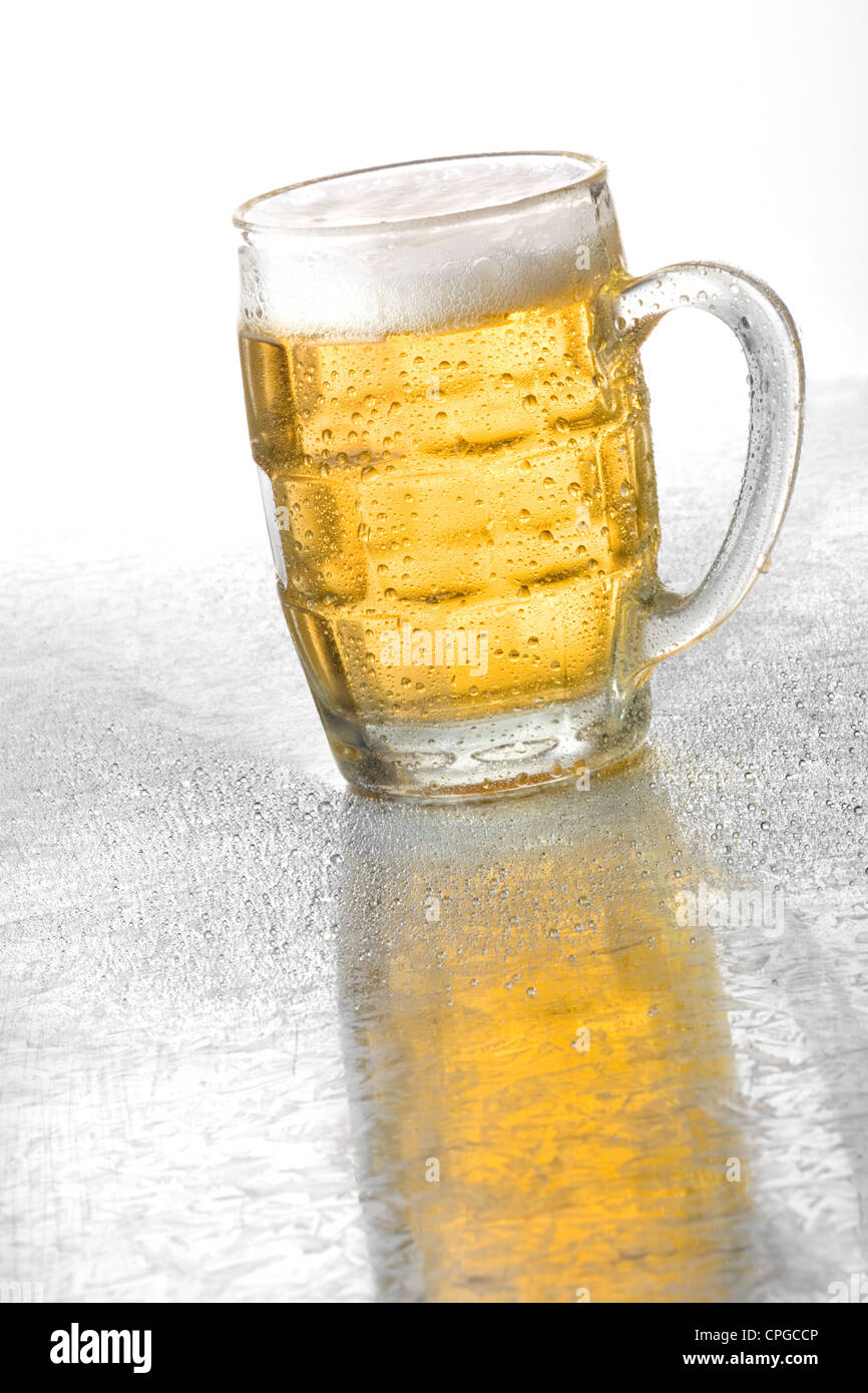 Glass of cold beer on a metallic surface with condensation drops Stock Photo