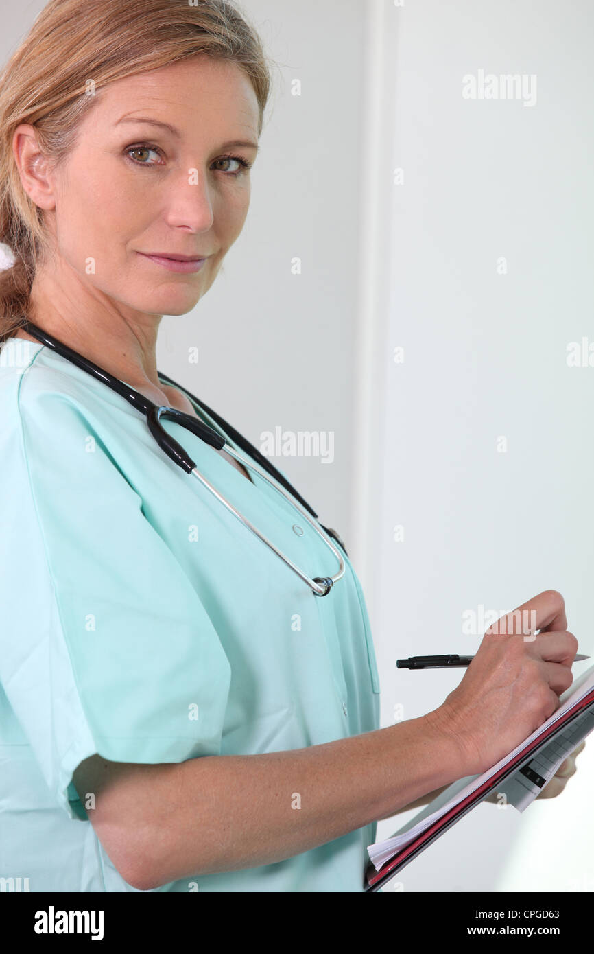 Female nurse holding clipboard and pen Stock Photo - Alamy