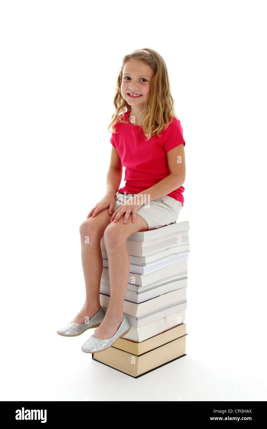Young girl on a stack of books Stock Photo - Alamy