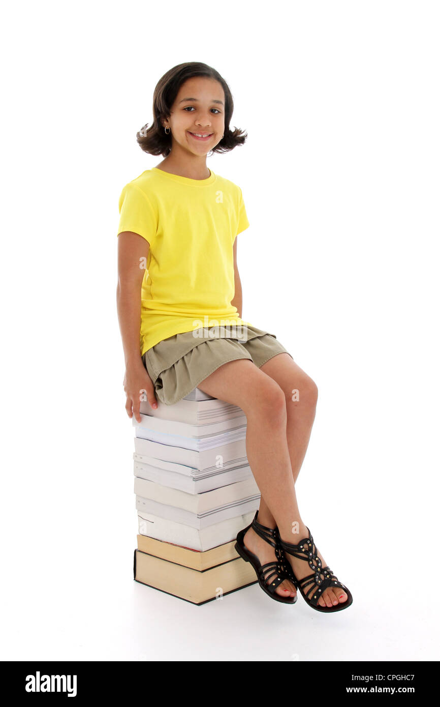 Young girl on a stack of books Stock Photo - Alamy
