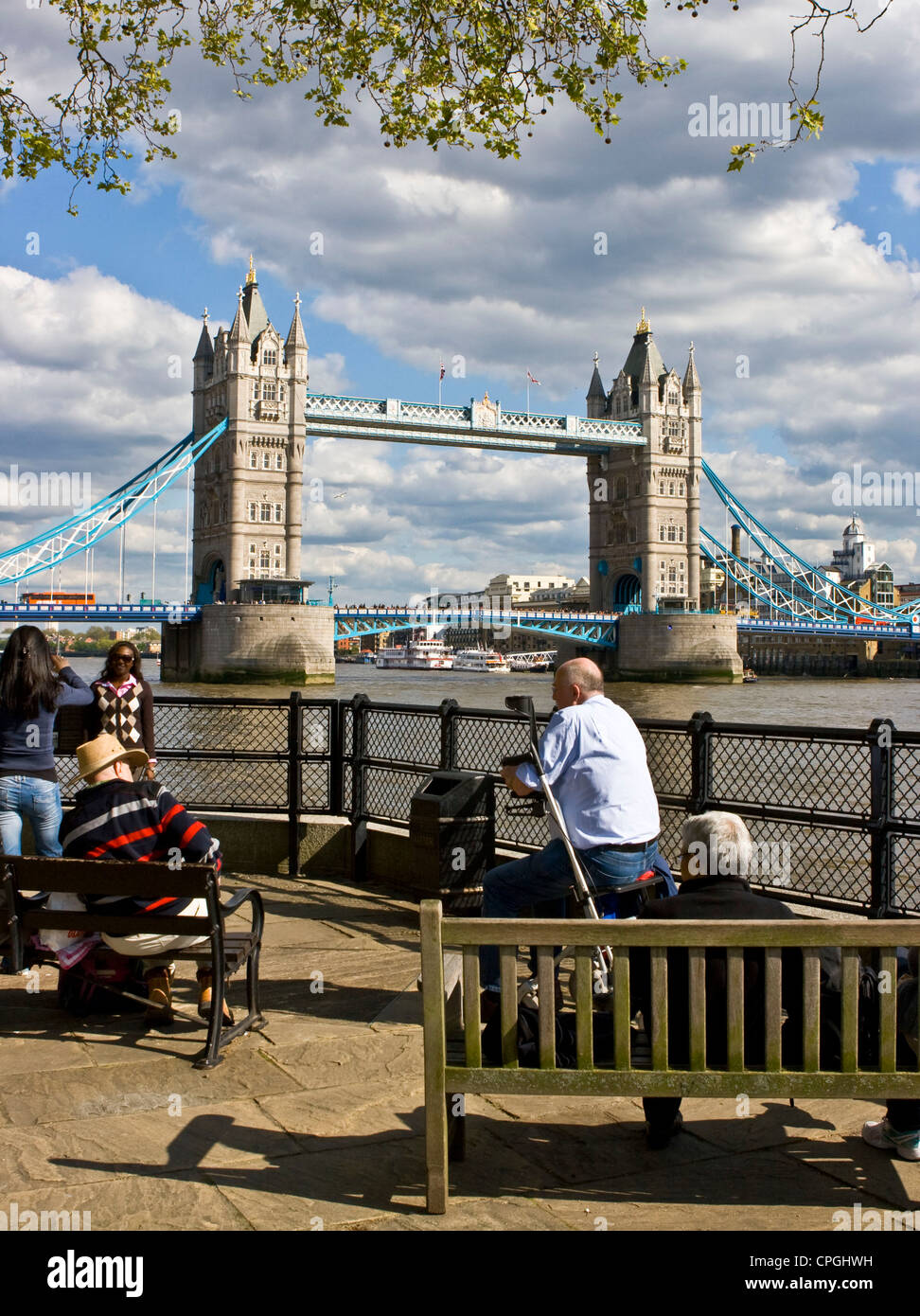 Tourists holidaymakers relaxing near grade 1 listed Tower Bridge London England Europe Stock Photo