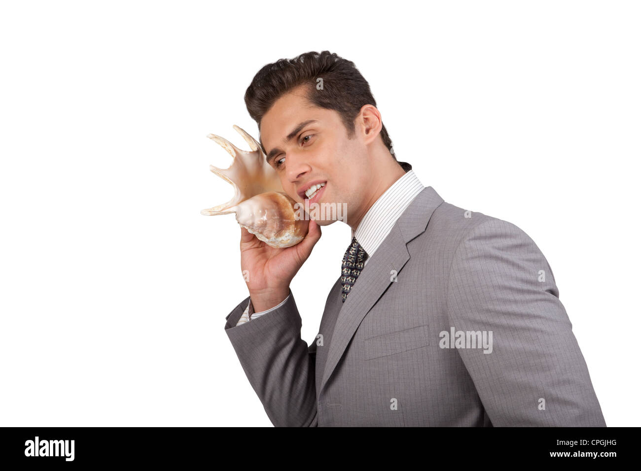 Businessman listening on shell Stock Photo - Alamy