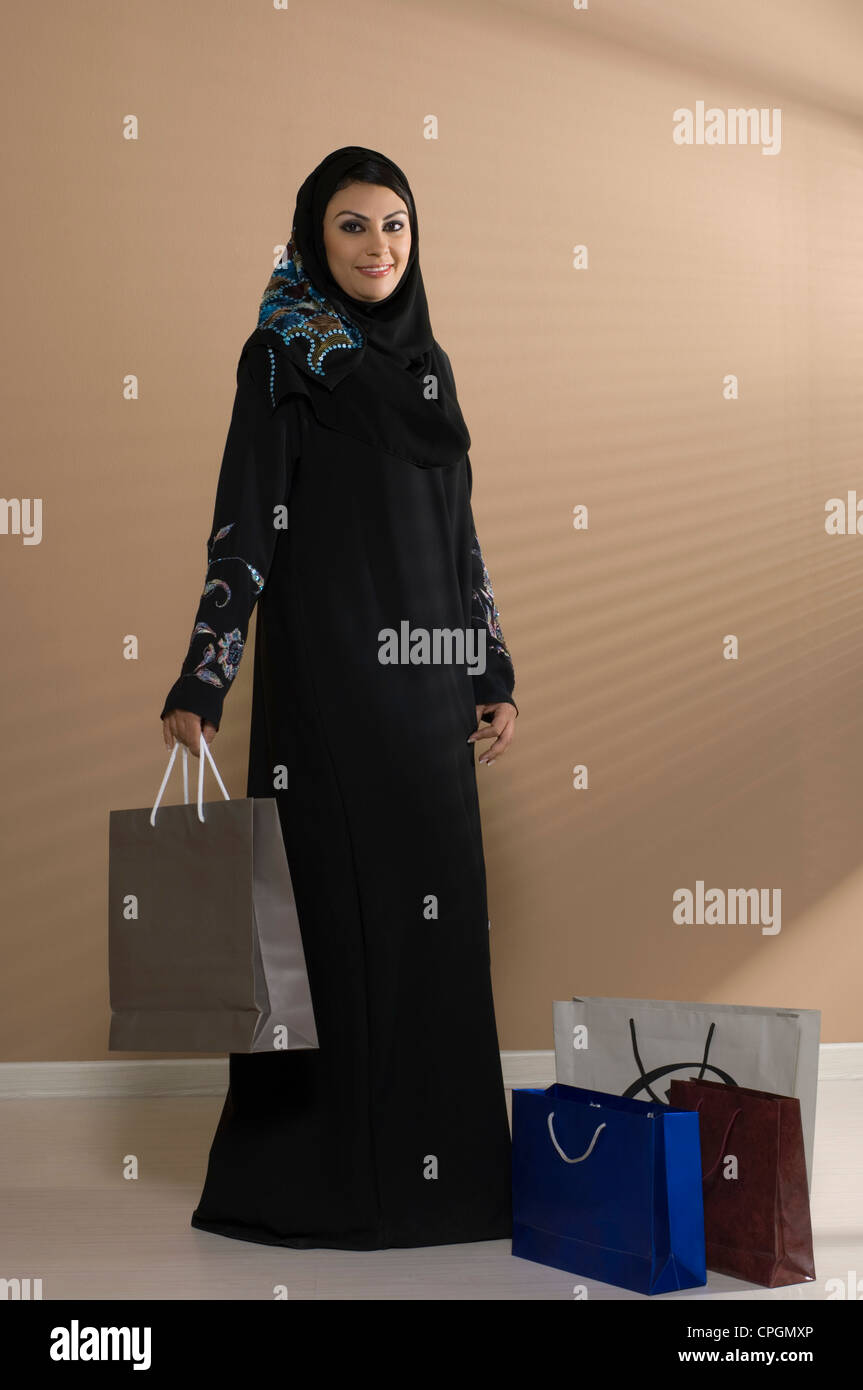 Young woman holding shopping bag, smiling, portrait Stock Photo - Alamy