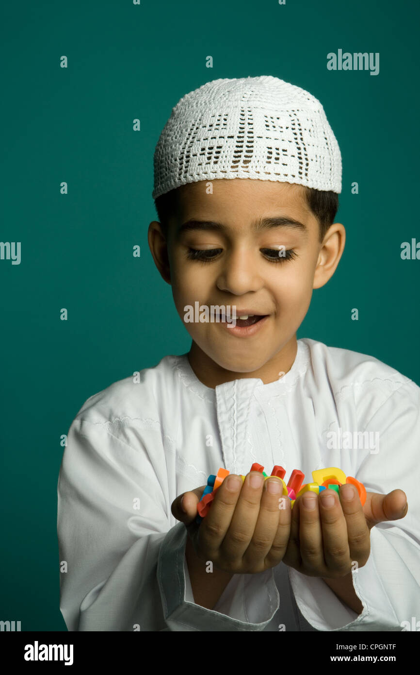 Boy (8-9 years) holding colorful alphabets, smiling Stock Photo - Alamy