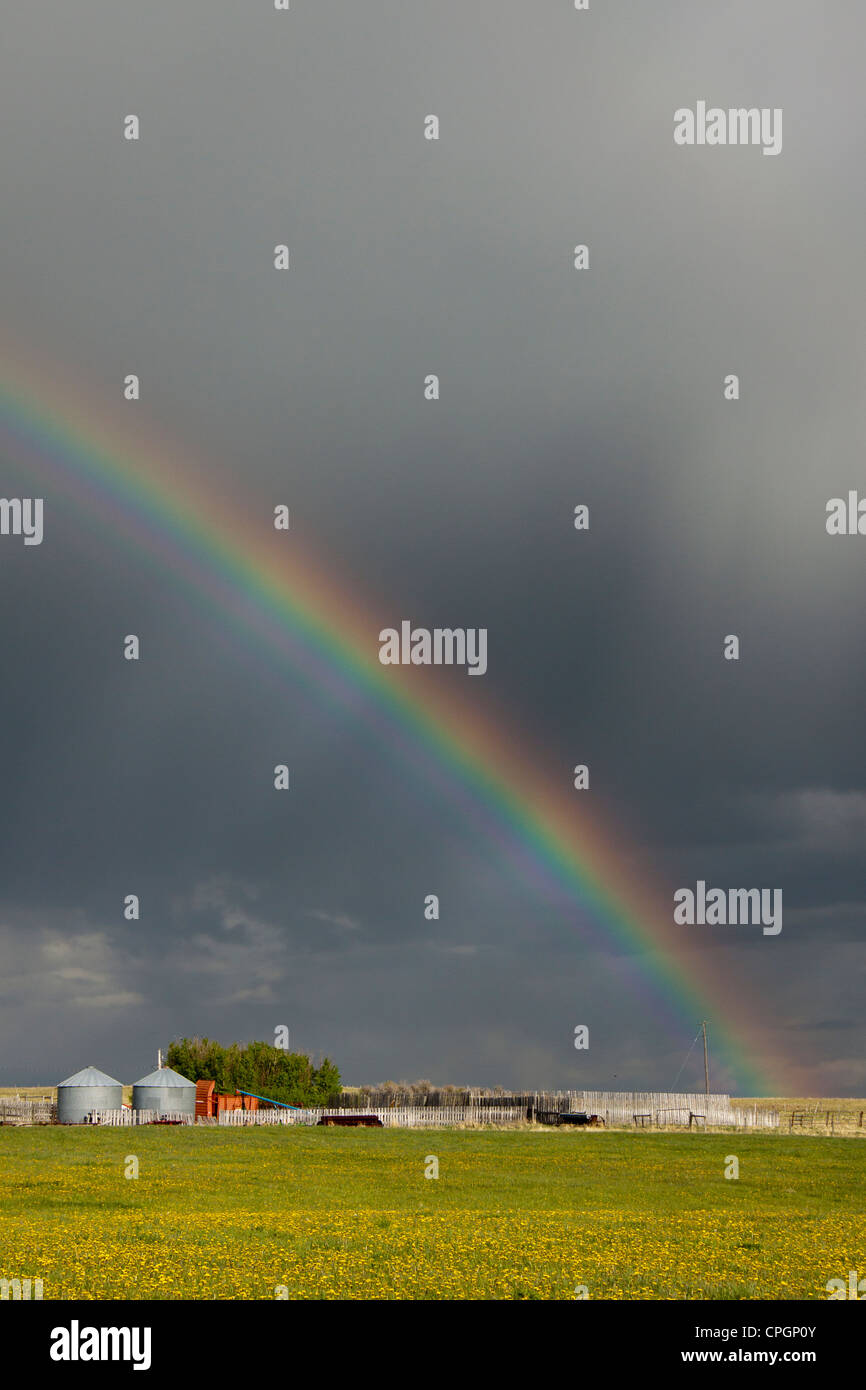 Rainbow over Canadian prairie farm Stock Photo