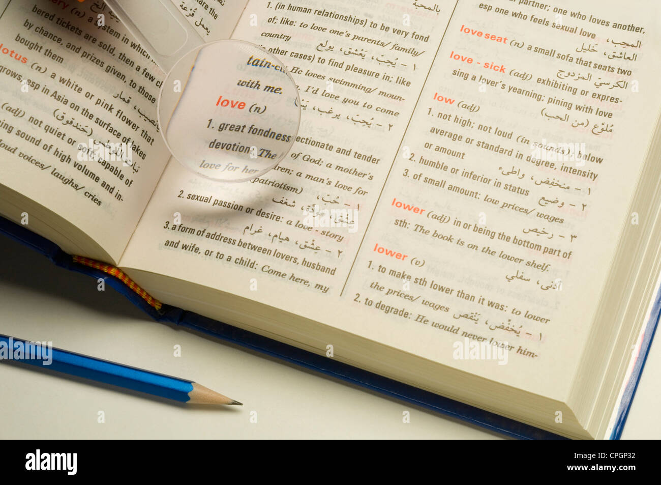 Magnifier on dictionary, closeup, elevated view Stock Photo Alamy