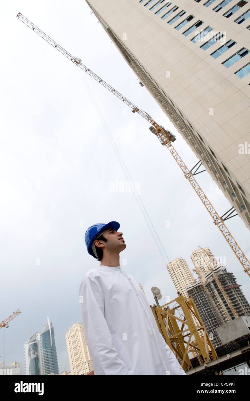 Premium Photo  An arab man, a businessman, a sheikh stands in front of a  skyscraper window. investments, business, work via the internet, online  contracts.