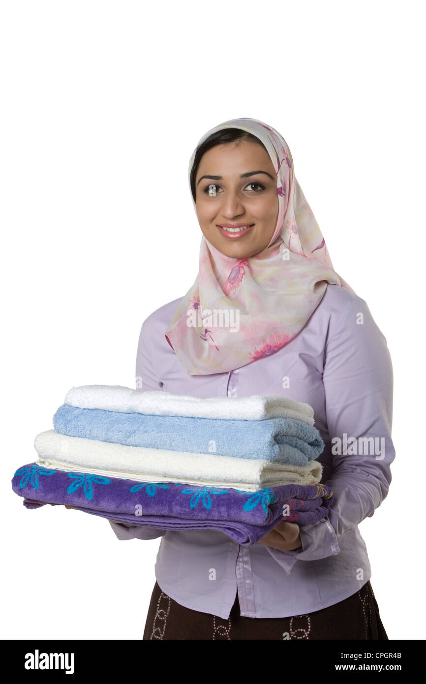 Young woman holding stack of towels, portrait Stock Photo - Alamy