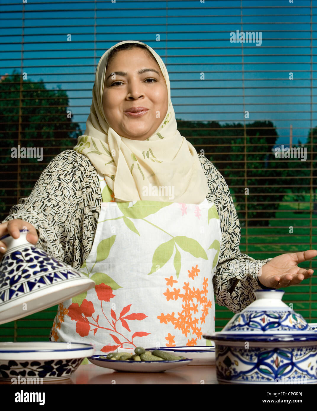 Mid adult woman holding crockery, portrait Stock Photo Alamy
