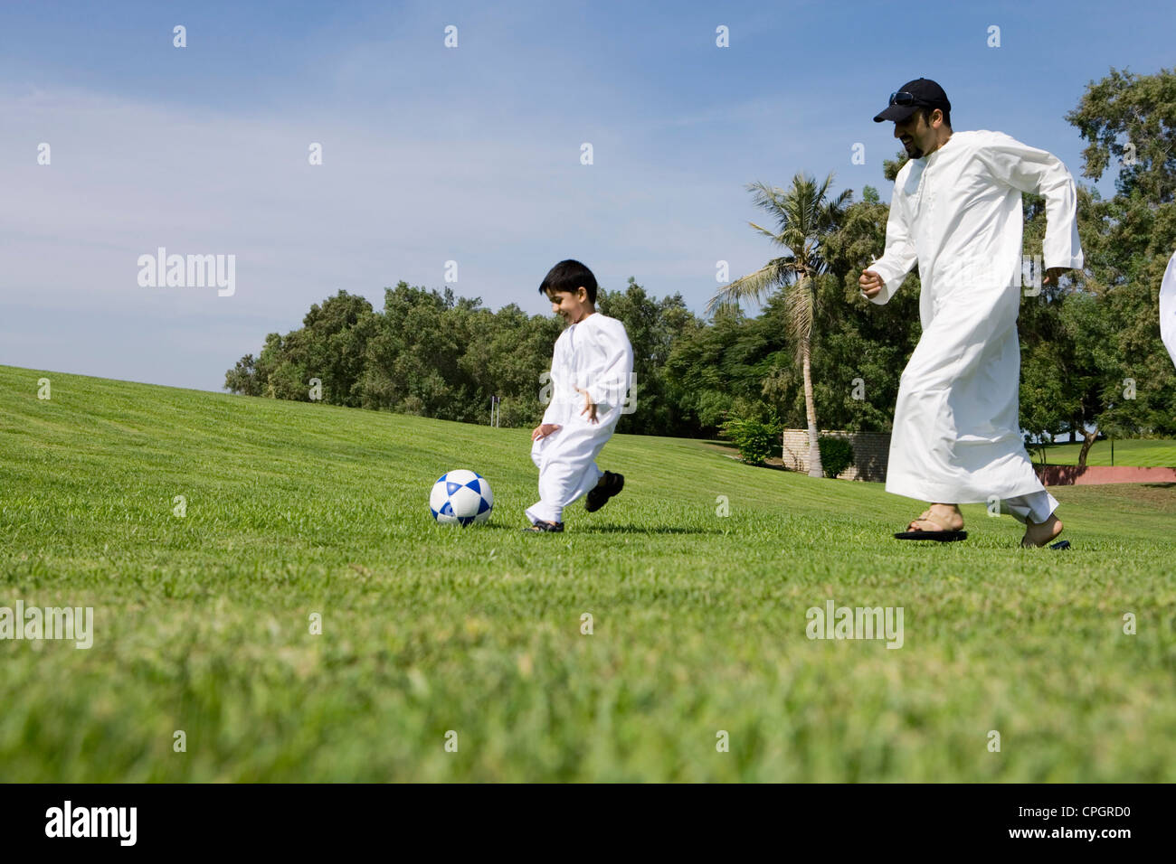 Father with son playing football in park Stock Photo - Alamy