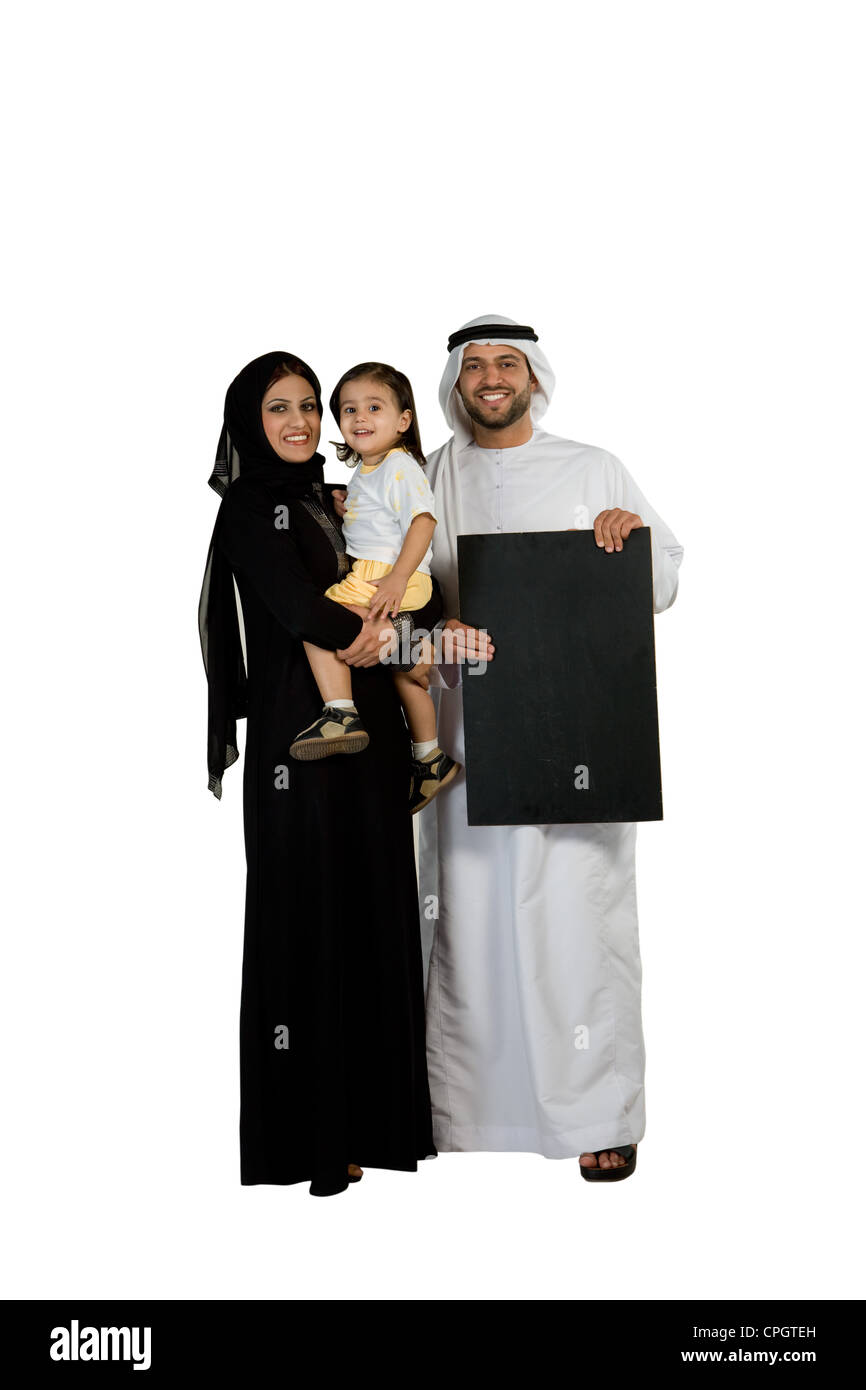 Arab family with placard, smiling, looking at the camera Stock Photo
