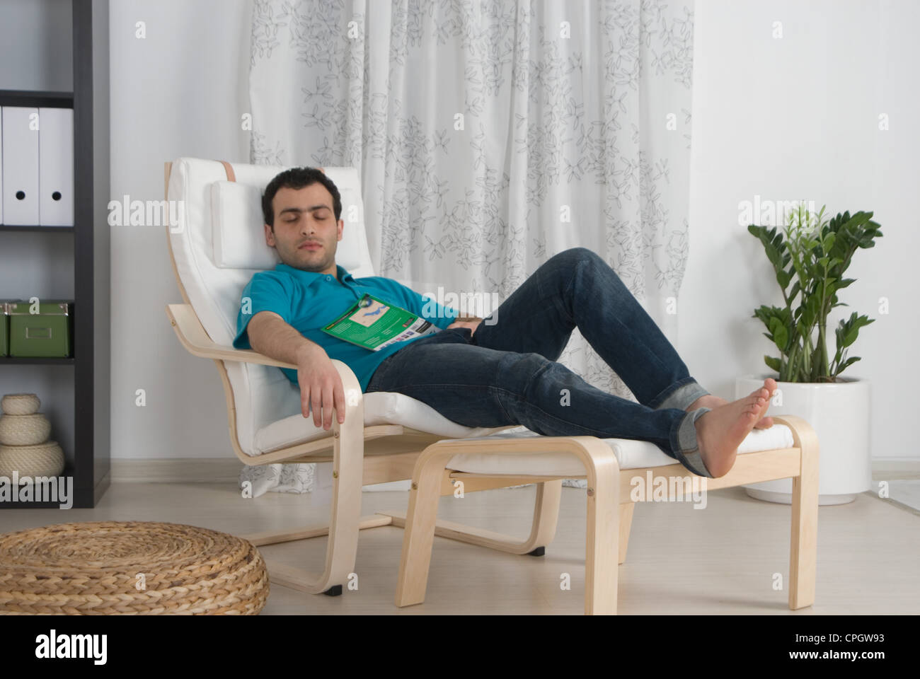 Man sleeping on armchair in the living room Stock Photo - Alamy