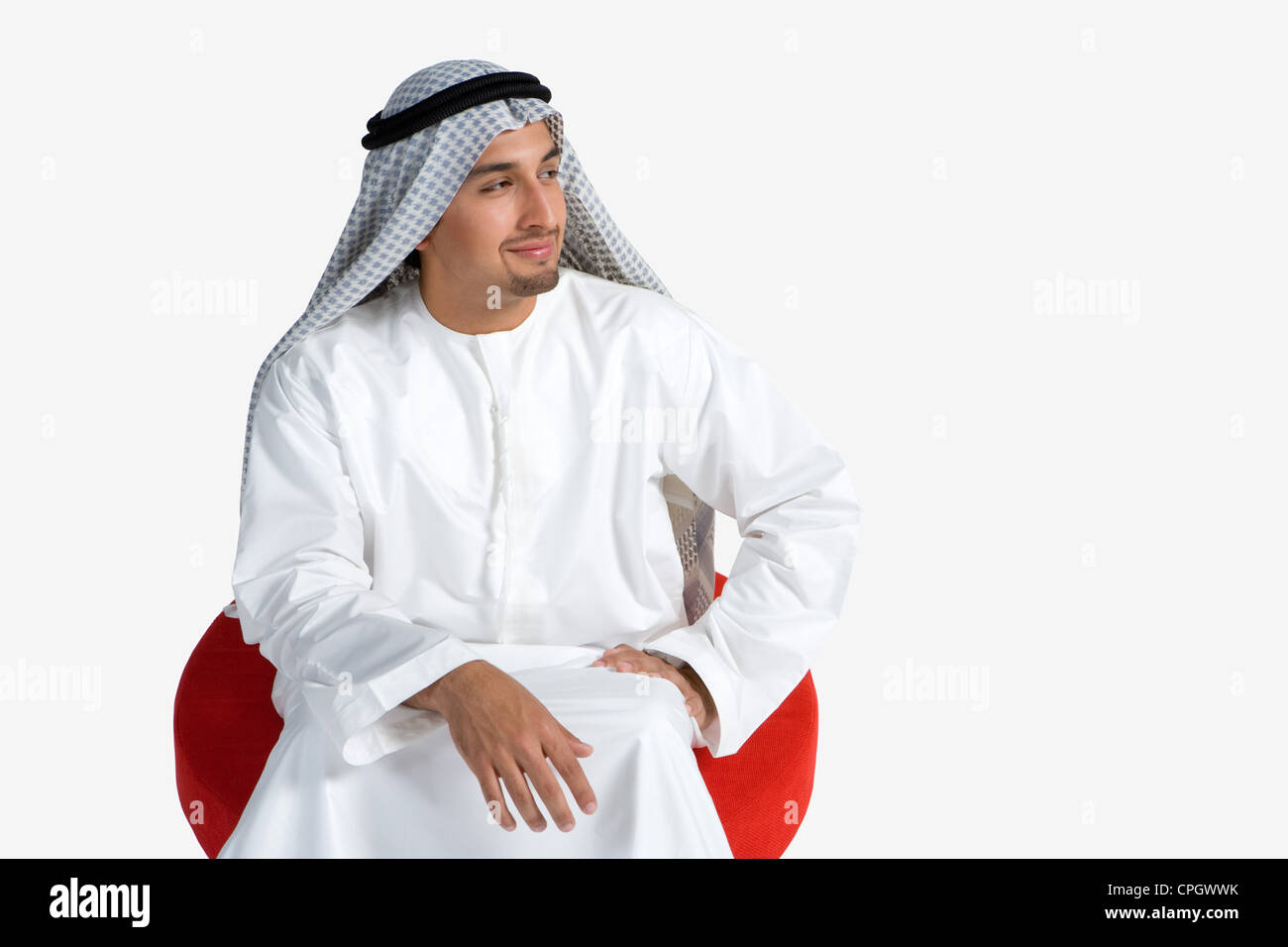 Young man sitting on chair, smiling Stock Photo
