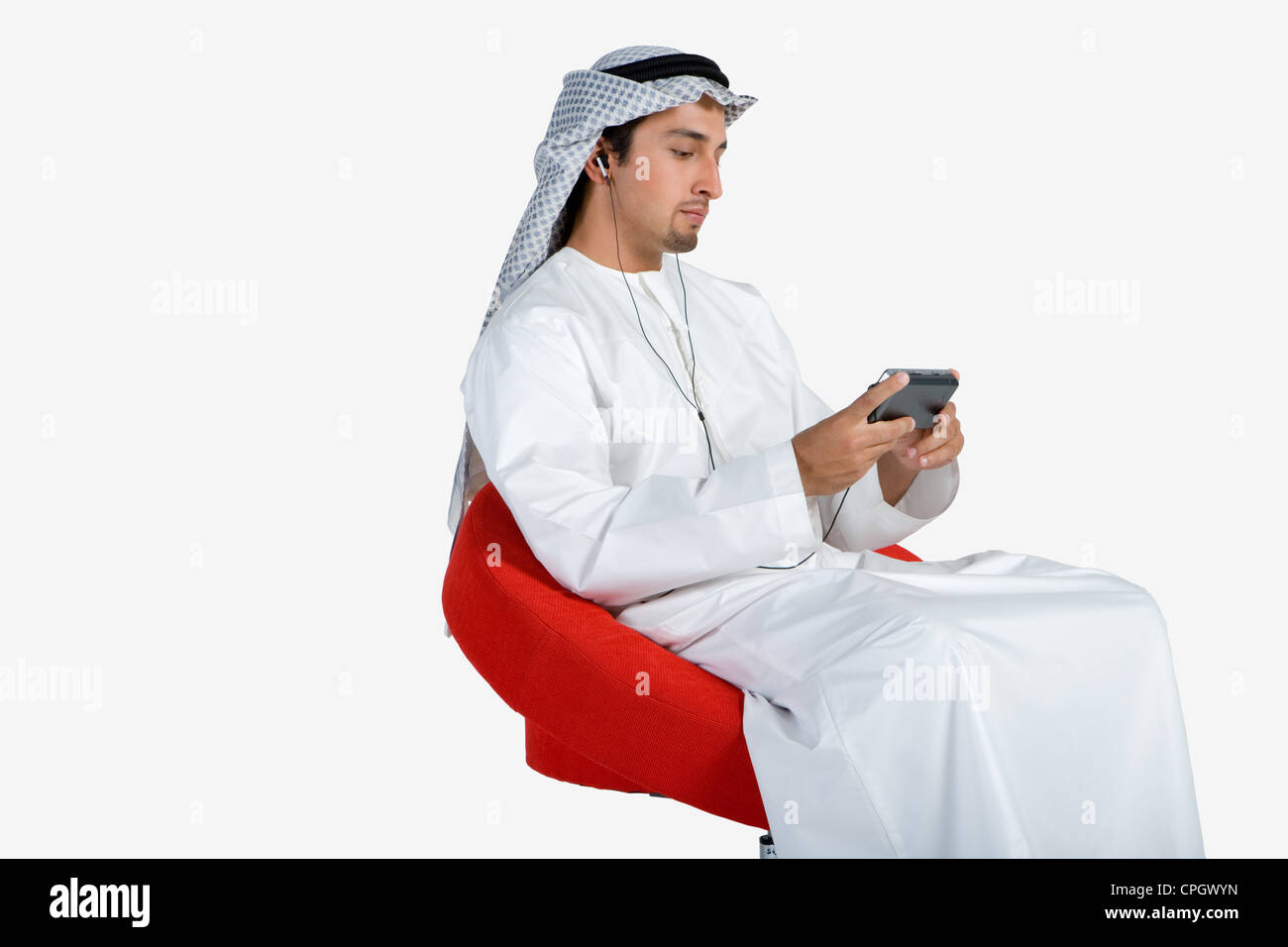 Young man sitting on chair, listening to music Stock Photo