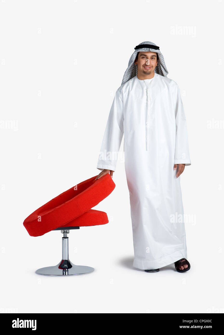 Young man standing near chair, portrait Stock Photo