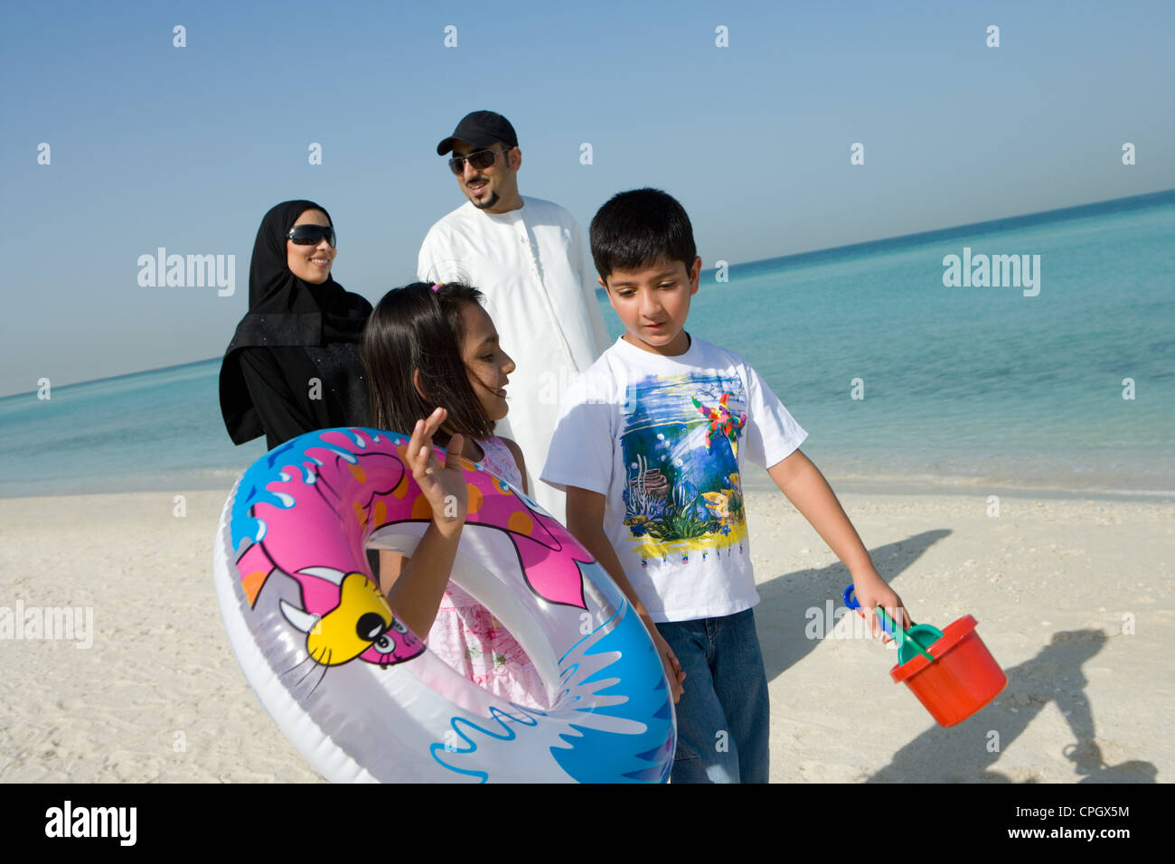 Family walking on beach, smiling Stock Photo - Alamy