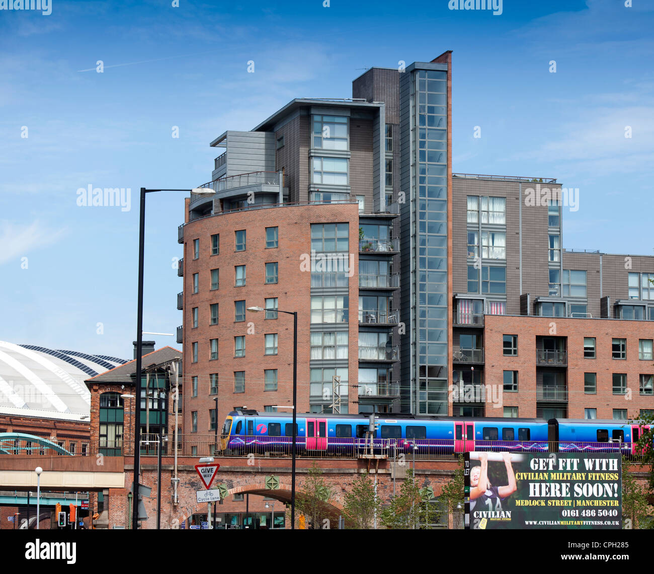 Stephenson Bell designed Hacienda apartments Manchester UK, a First Group train heads to Deansgate Station Stock Photo