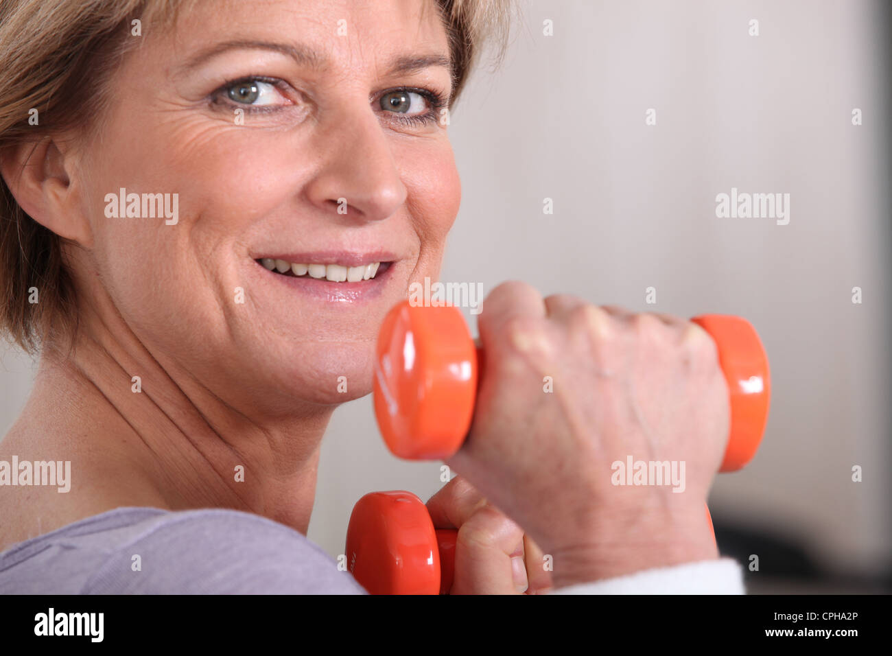 Woman lifting dumbbells at the gym Stock Photo