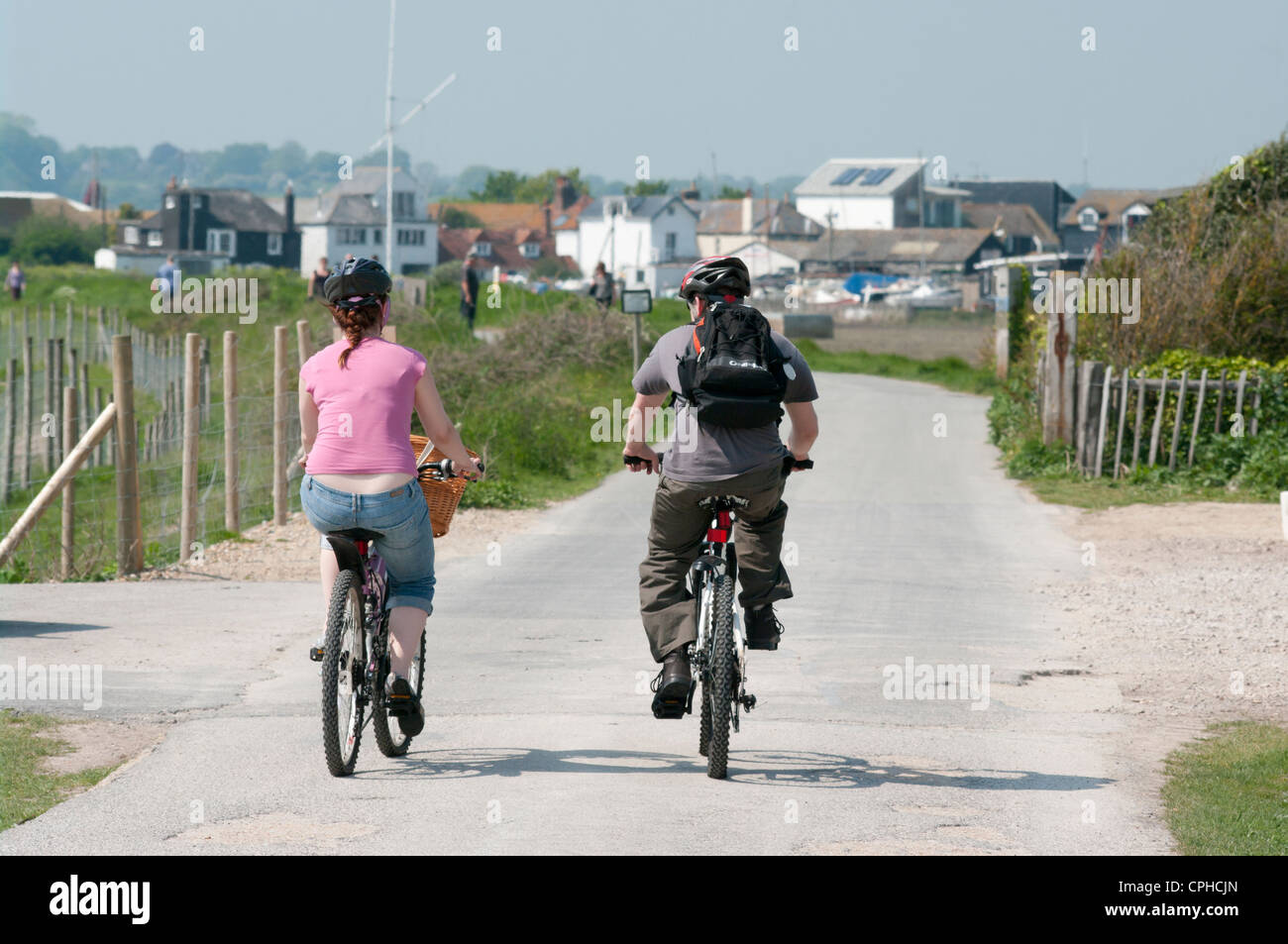 Young Couple Riding Bikes Cycles Bicycles Along A Cycle Path Stock Photo