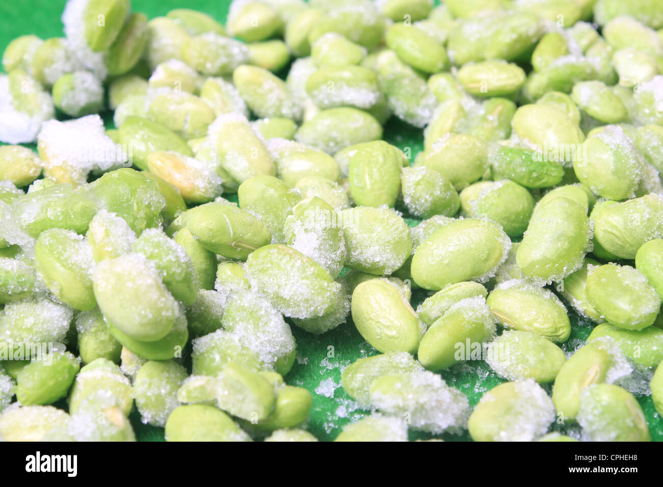 Frozen edamame also known as soybeans on a green background Stock Photo