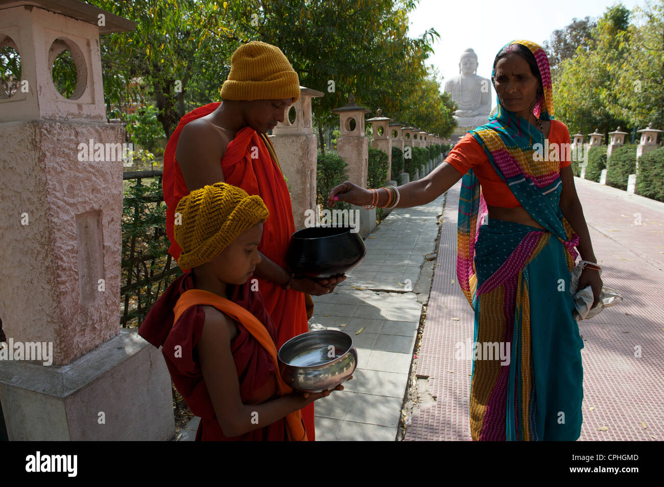 Collecting alms, Giant Buddha statue, Bodh Gaya, Bihar, India Stock Photo