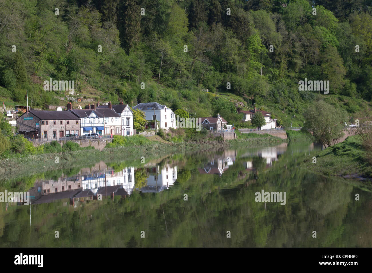 Tintern village. Houses and trees reflected in the river Wye at Tintern