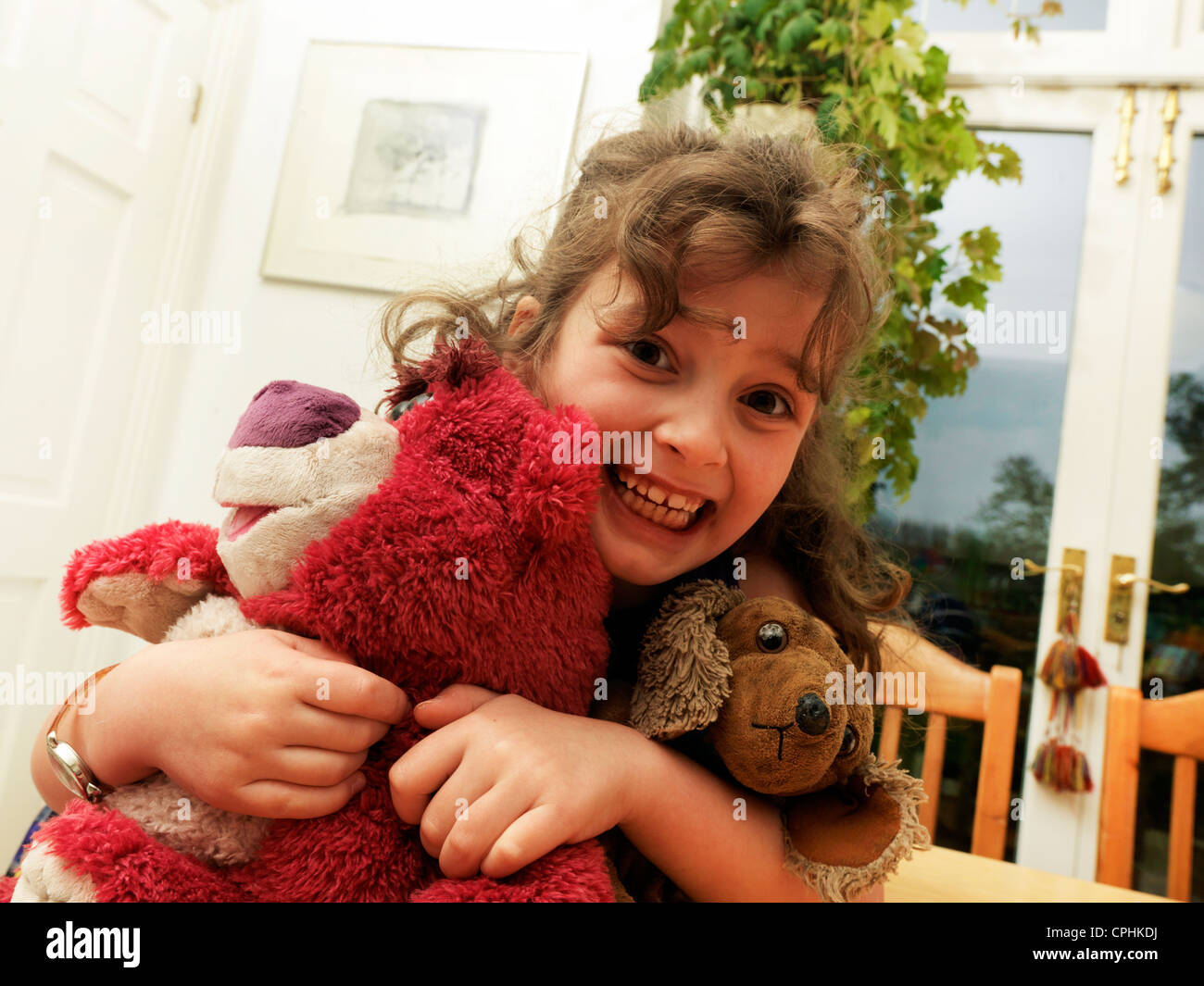 Young Girl Hugging A Pink Teddy Bear And A Cuddly Dog Surrey England Stock Photo