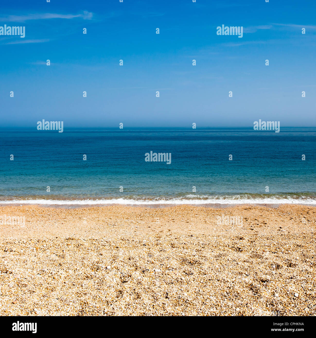 Footprints in a pebble beach on a warm summers day. Stock Photo