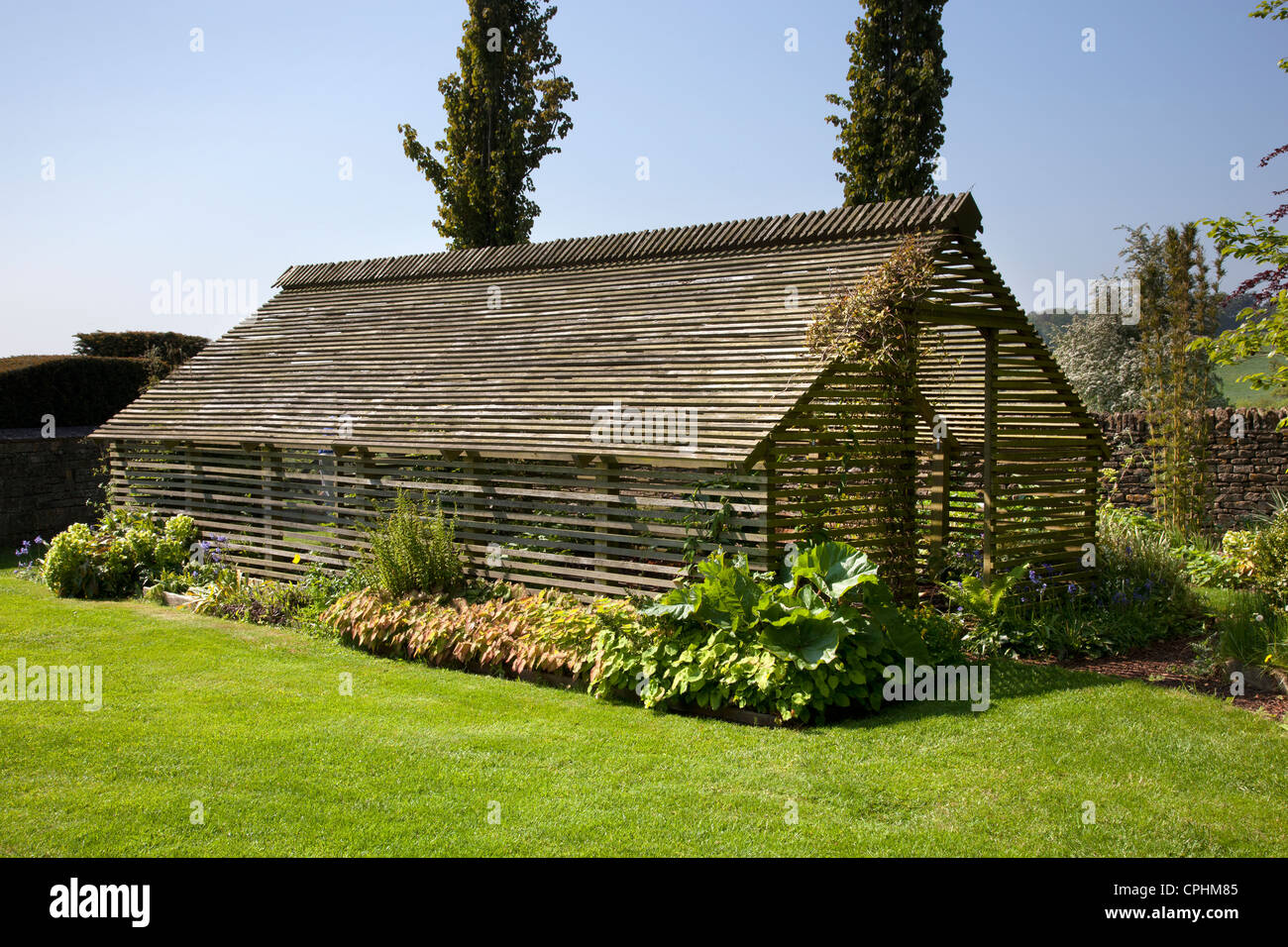 Wooden slated plant shade house garden, England Stock Photo