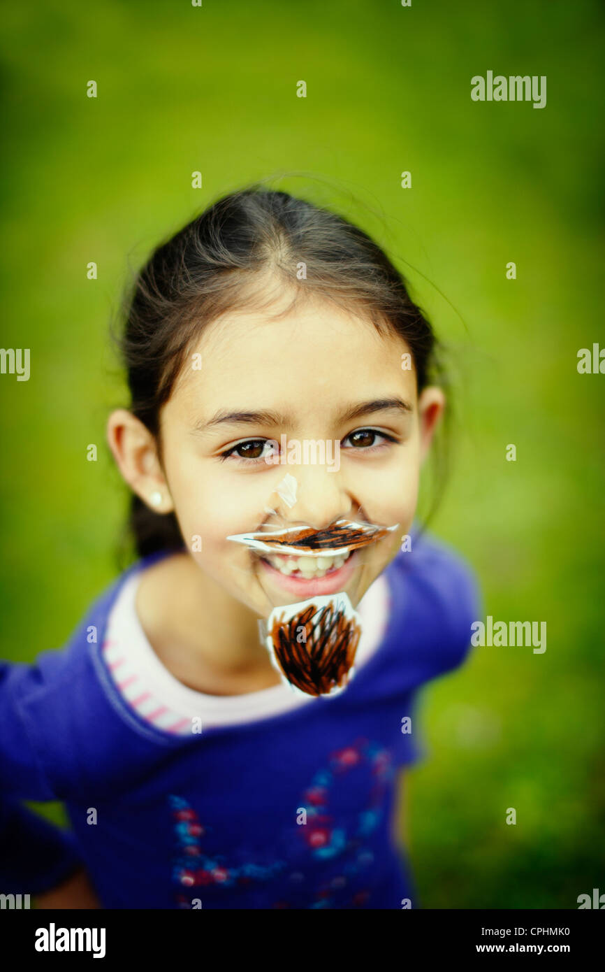Movember. Girl with her homemade moustache and beard which she has stuck to her face with sticky tape. Stock Photo