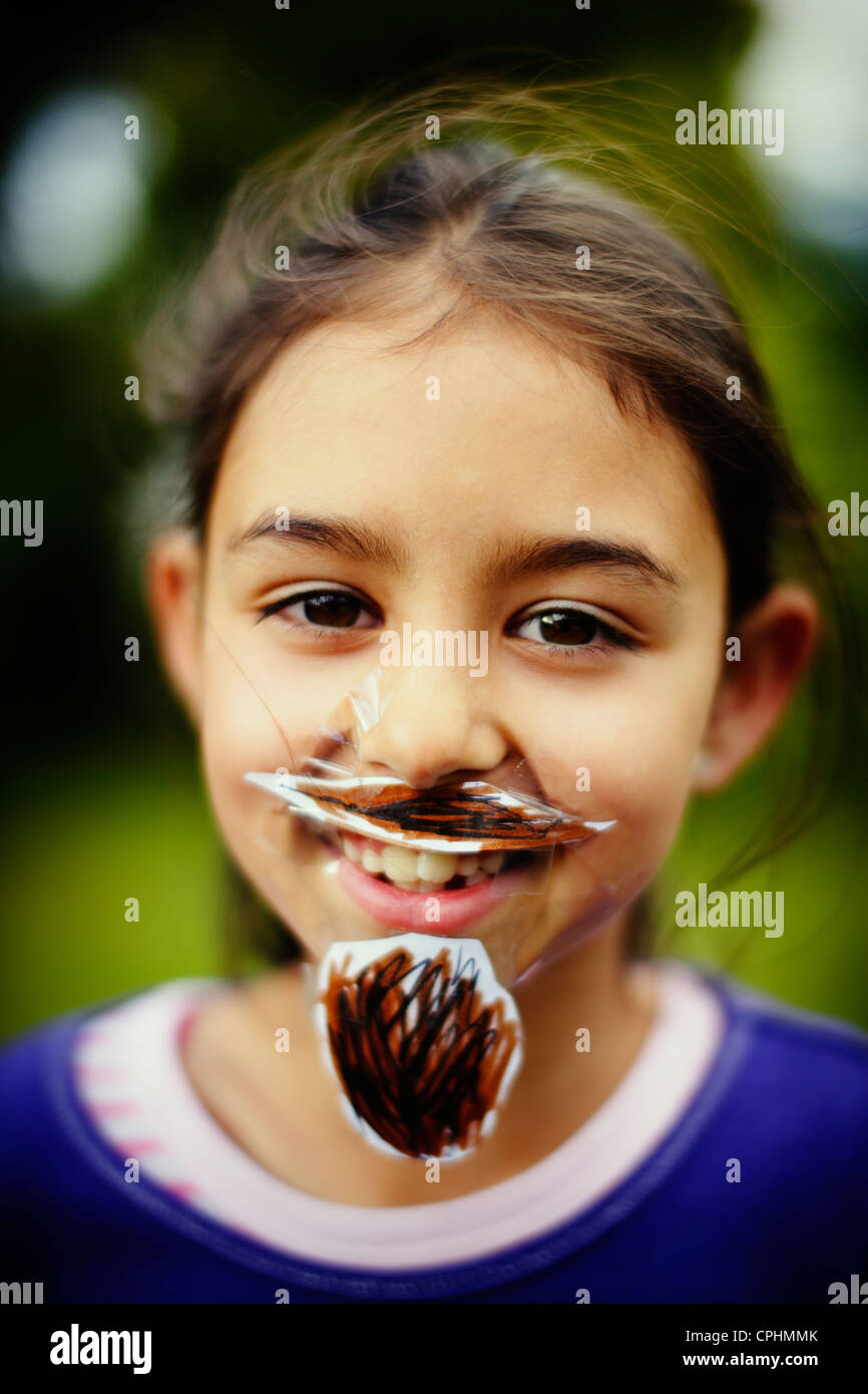 Movember. Girl with her homemade moustache and beard which she has stuck to her face with sticky tape. Stock Photo