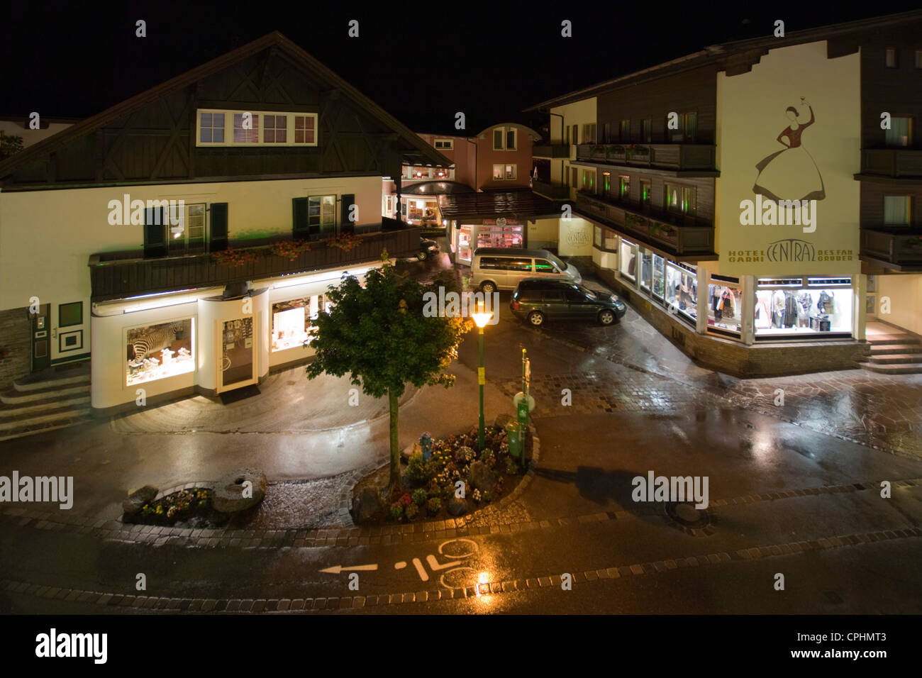 Nighttime view of Hauptstrasse, Mayrhofen with the wet cobbles illuminated by the shop windows Stock Photo