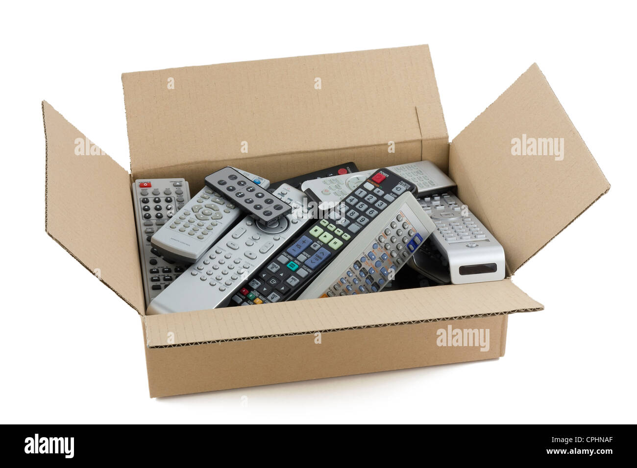 In a cardboard industry box are old faulty broken audio and video remote controls. Devices are prepared for recycling on garbage Stock Photo