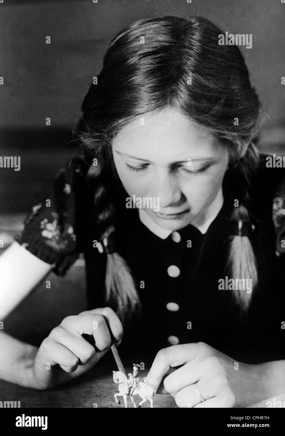 Girl paints tin soldiers, 1933 Stock Photo