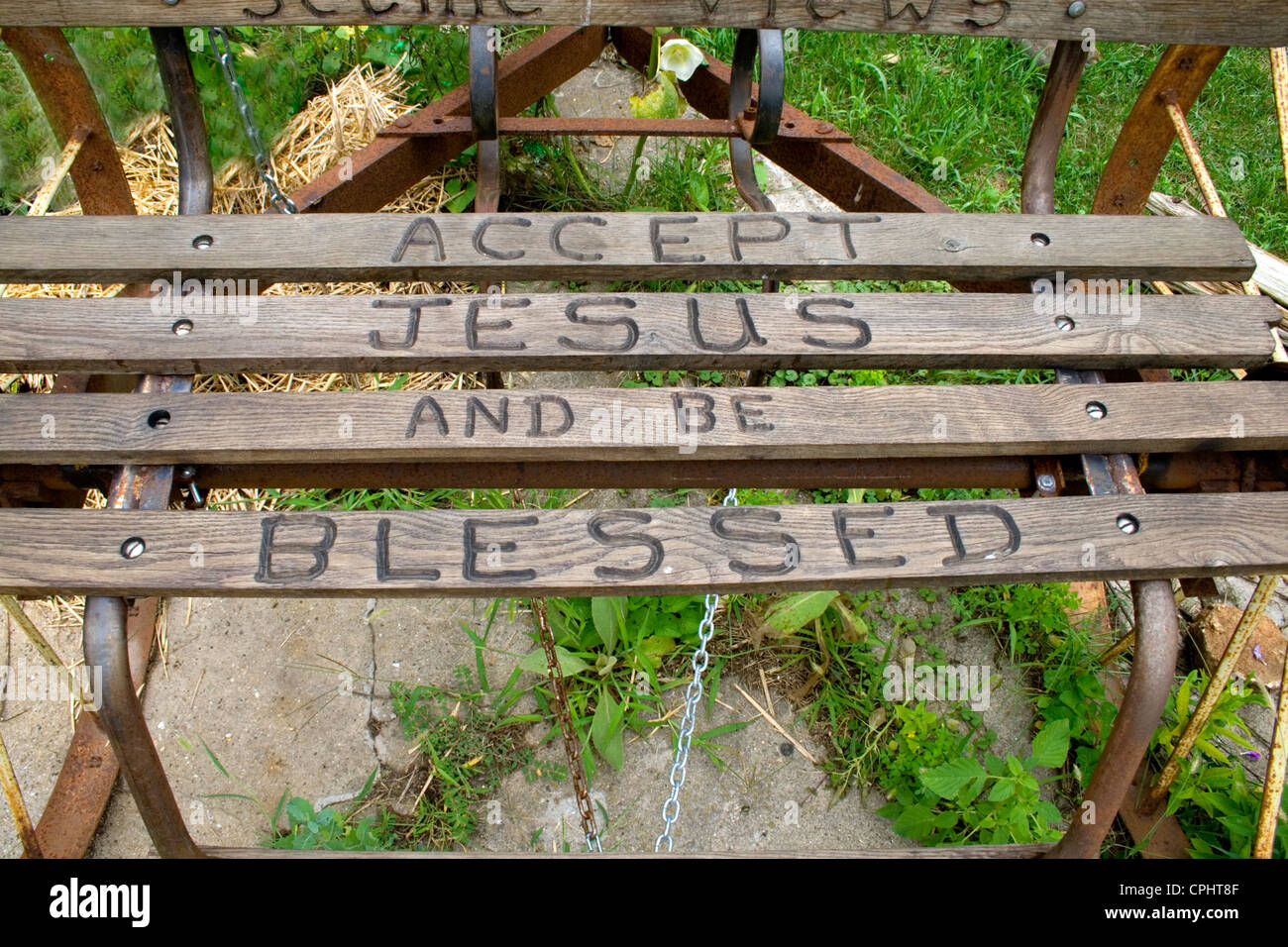 Norma's flower garden with antique bench carved with the reminder to Accept Jesus and be blessed. Lanesboro Minnesota MN USA Stock Photo