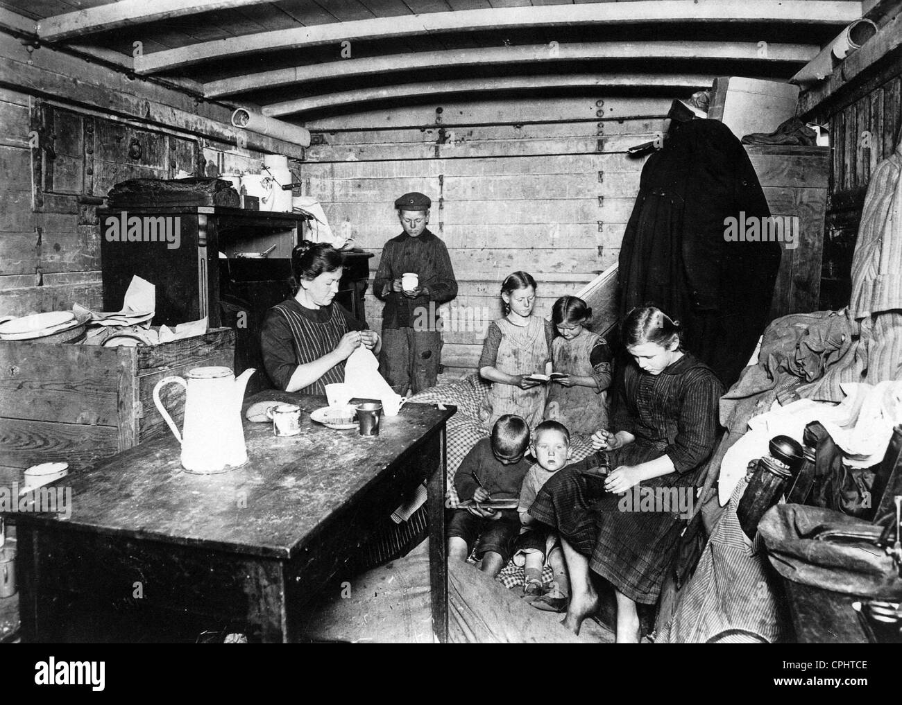 A family living in temporary accomodation in an old railway carriage due to the housing shortage in Berlin, July 1920 (b/w Stock Photo
