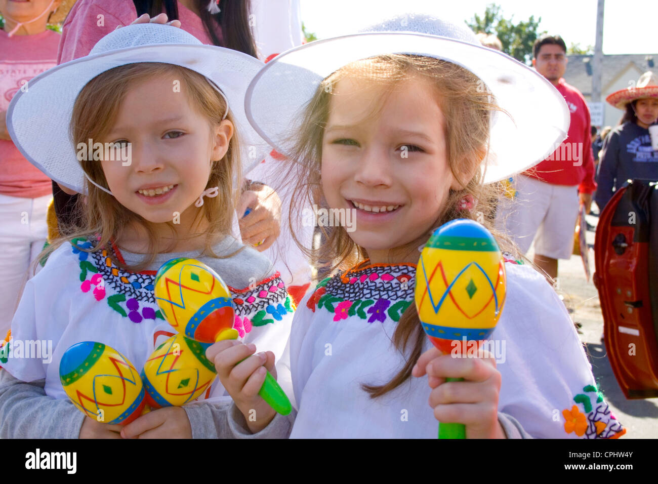 Happy young girls shaking maracas in the parade. Mexican Independence Day Minneapolis Minnesota MN USA Stock Photo