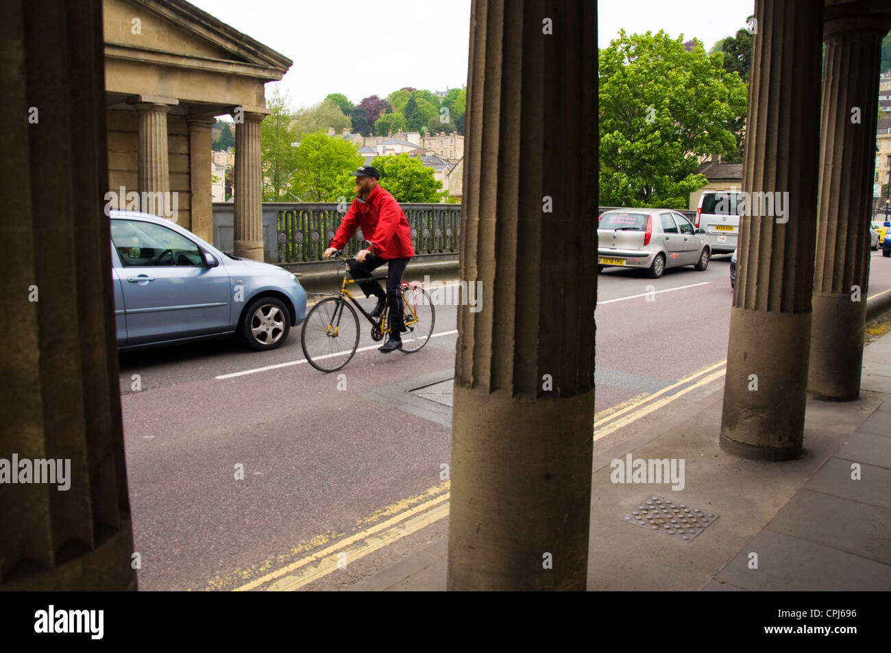 Man cycling in traffic in Bath Stock Photo