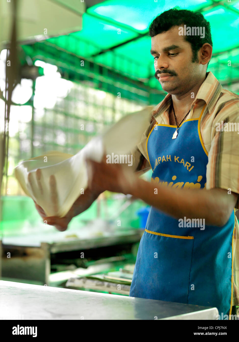 A street vendor preparing traditional Indian Roti Canai flatbread Stock Photo