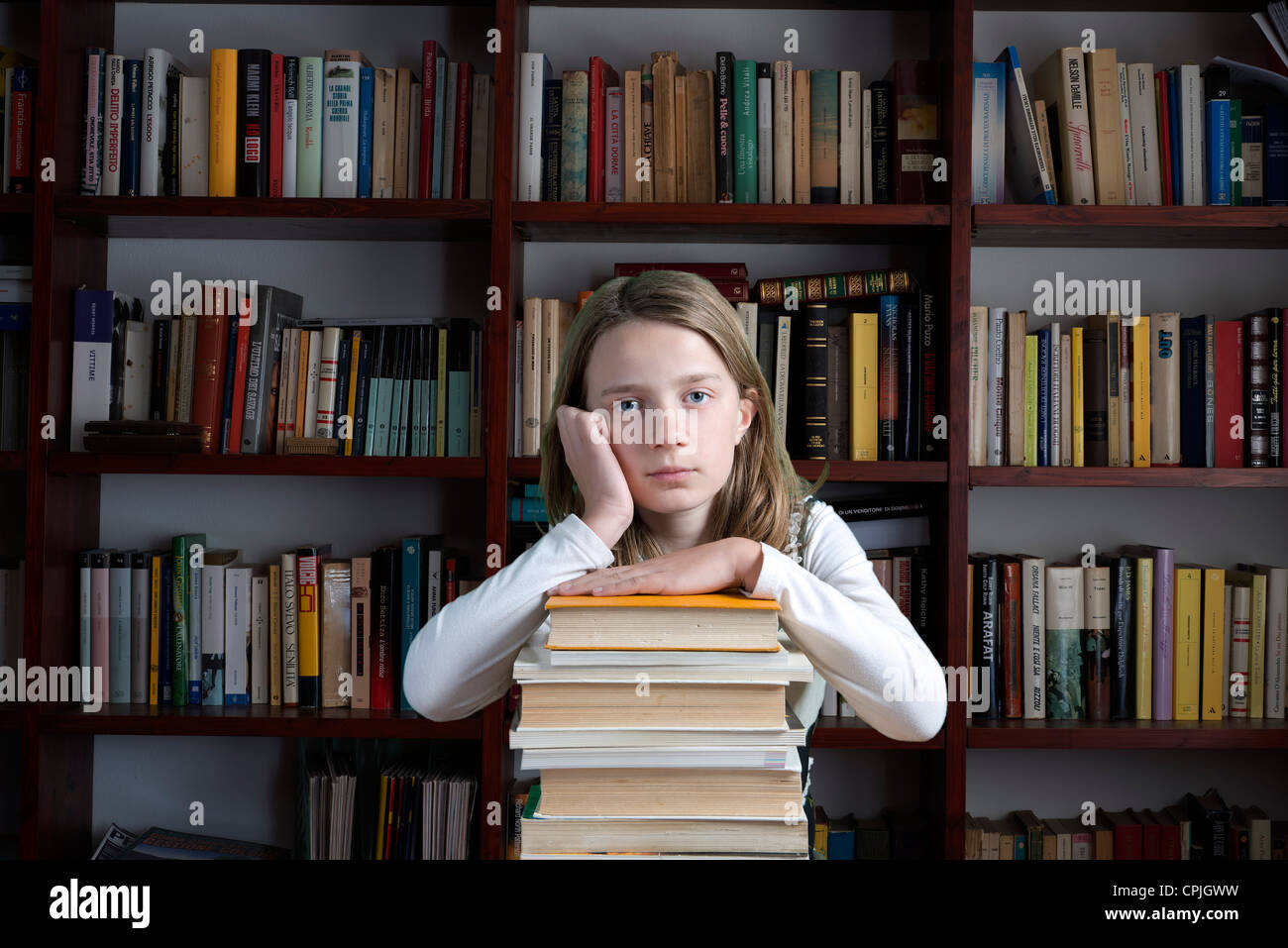 Girl sitting on pile of books reading hi-res stock photography and ...
