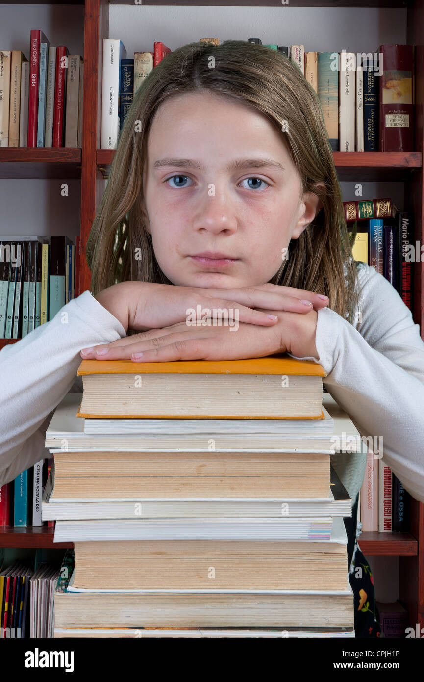 a girl resting on a pile of books Stock Photo - Alamy