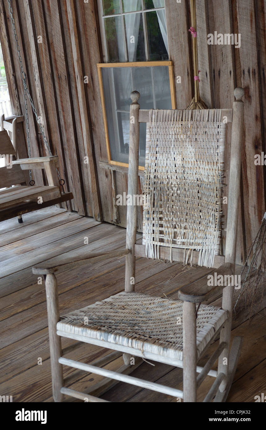 Antique rocking chair on a historical cabin's front porch Stock Photo