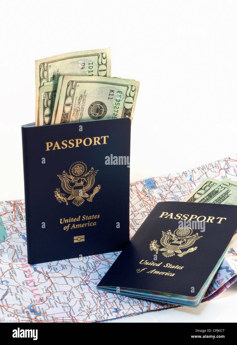 Two American passports with paper money and open map isolated on white background. Stock Photo