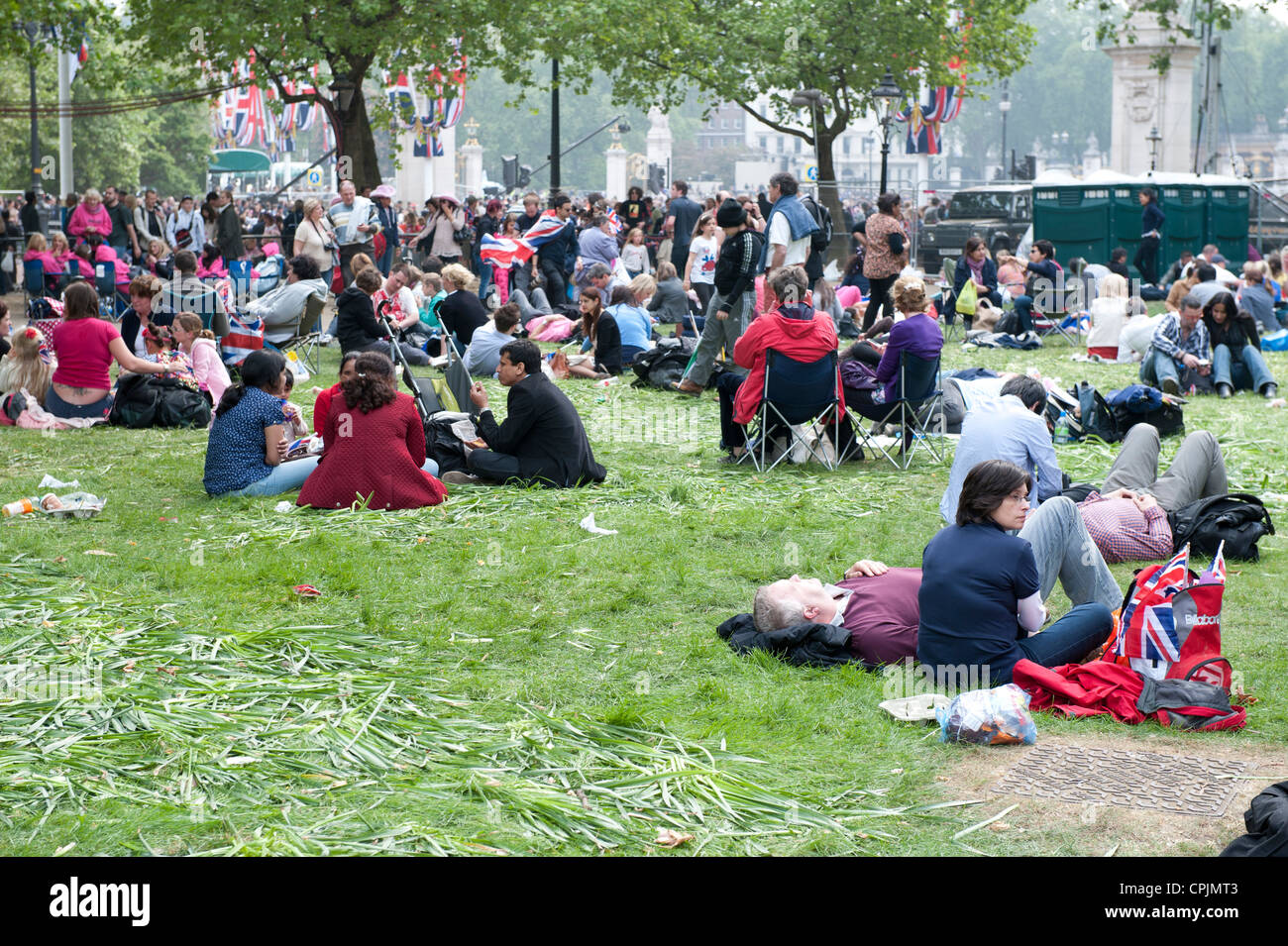 Members of the public sitting on the grass in Green Park following the marriage of Prince William to Catherine Middleton. Stock Photo
