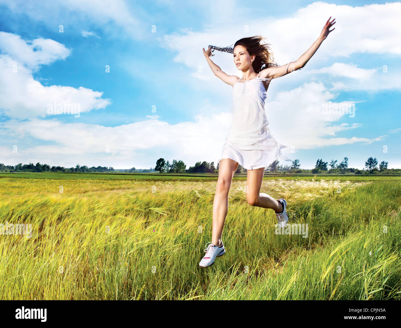 pretty woman running across field Stock Photo