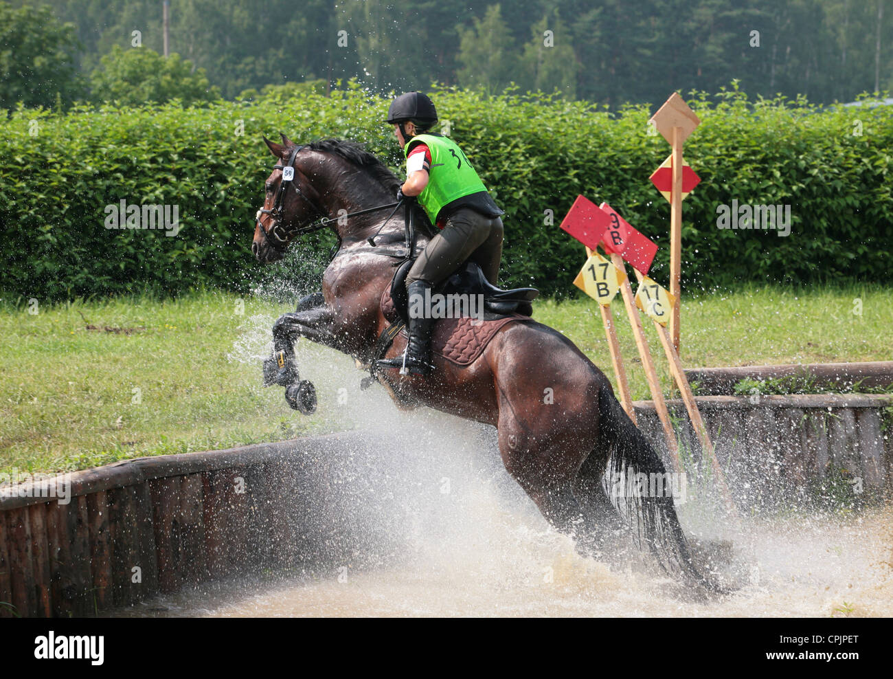 Horse rider jumps a water obstacle during a three day eventing Stock Photo