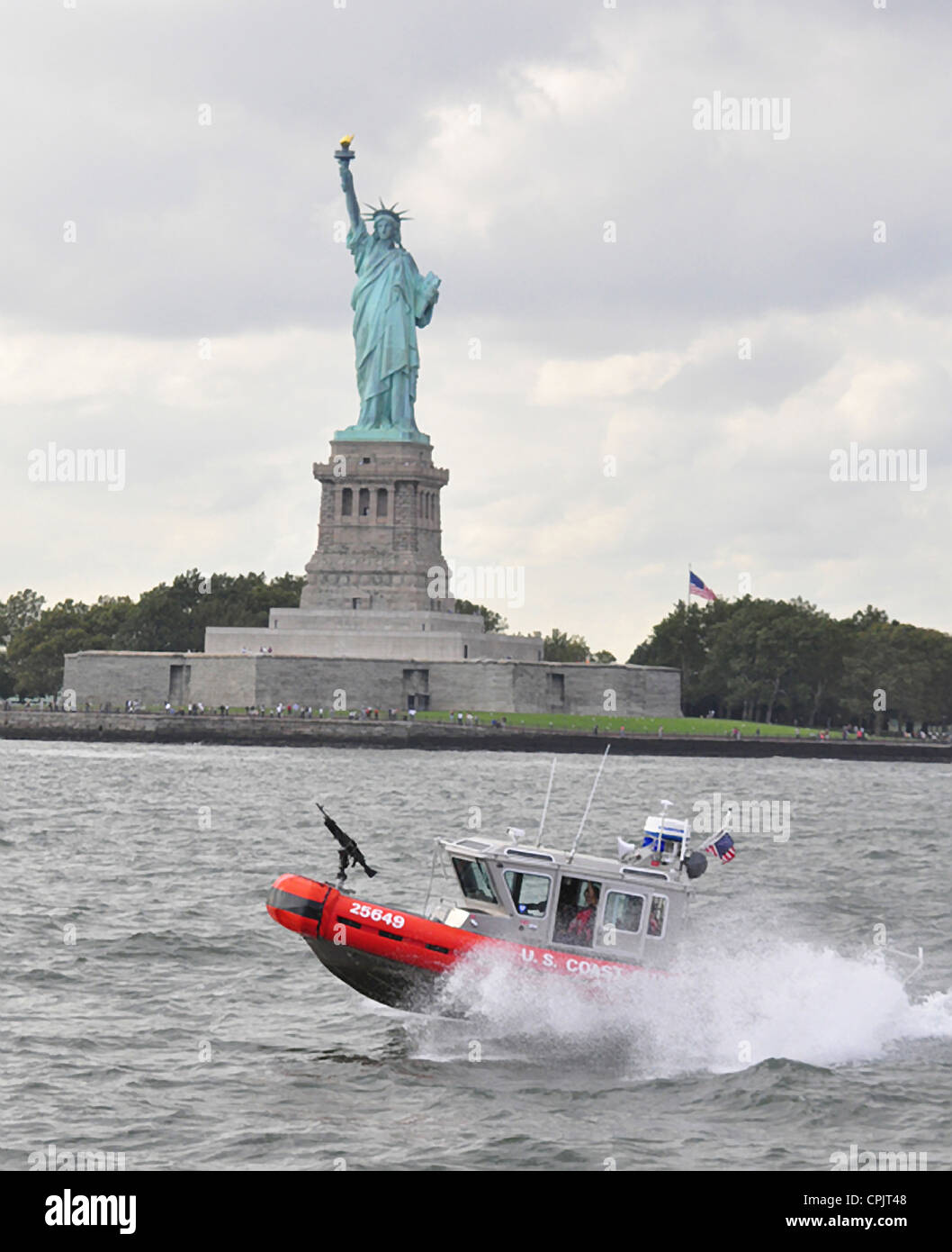 A USCG 25-foot rapid response boat patrols New York harbor past the Statue of Liberty September 23, 2009 in New York, NY. Stock Photo
